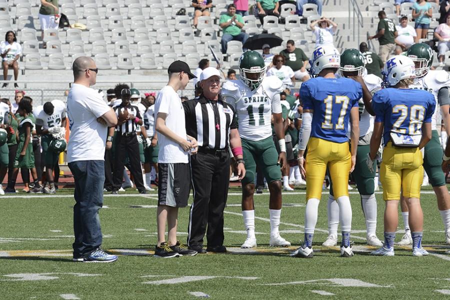 Jacob and his dad participate in the coin toss.