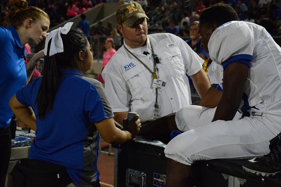 Trainers assist football player during game. Concussions are a large concern for football players. 