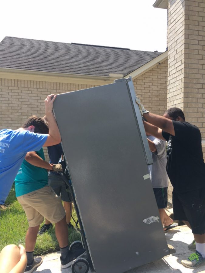 Orchestra members help family move damaged furniture and appliances.