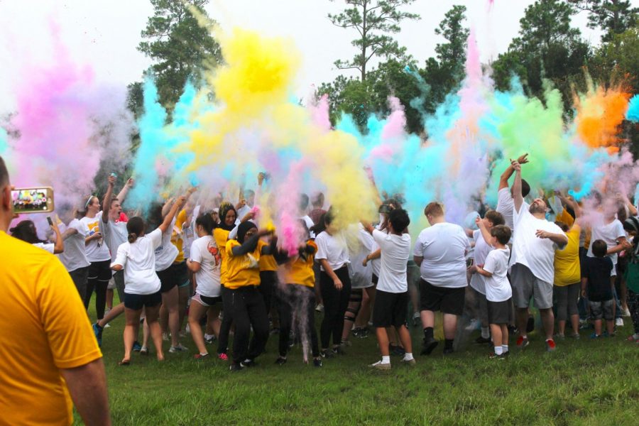 Everyone that is participating gathers to begin the color run by throwing the color in the air.