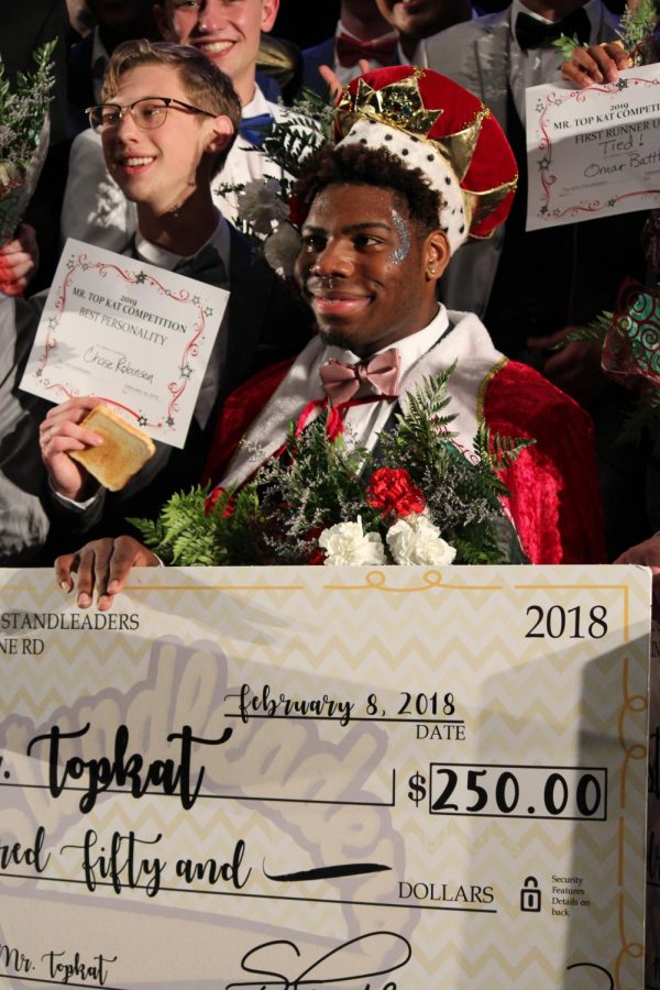 Winner Senior Joshua Davis holds up his check of $250 as the rest of the contestants gather behind him.