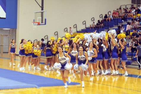 Klein High School varsity cheerleaders rush to the other side of the gym in preparation for their next combination of flips and turns that wow the crowd.